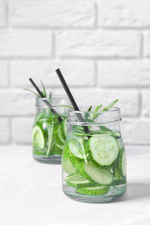 Natural lemonade with cucumber and rosemary in jars on tableの写真素材