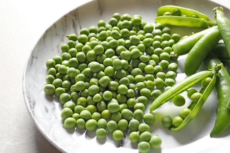 Plate with green peas on light background, closeupの写真素材