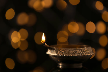 Diwali diya or clay lamp against blurred lightsの写真素材
