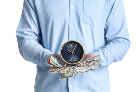 Young man holding alarm clock and cash on white background. Time is money conceptの写真素材