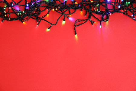 Glowing Christmas lights on color background, top viewの写真素材