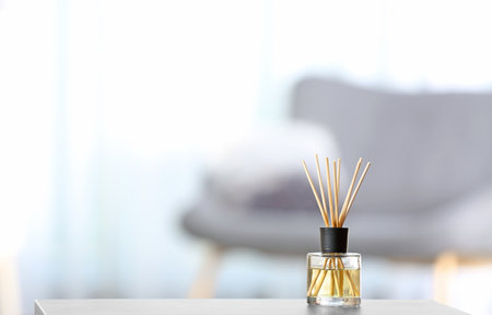 Aromatic reed air freshener on table against blurred backgroundの写真素材