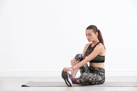 Female athlete suffering from leg pain during training indoors