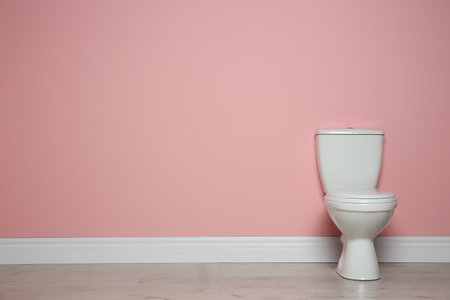 New ceramic toilet bowl near color wall with space for textの写真素材