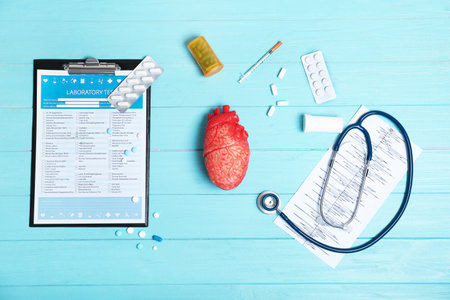 Flat lay composition with stethoscope and pills on wooden background. Cardiology serviceの写真素材