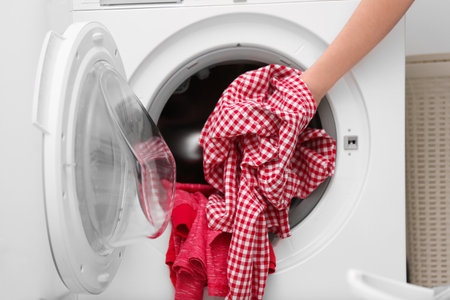 housewife putting clothes into washing machineの写真素材