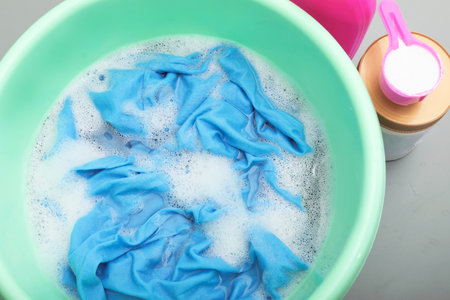 Color clothes with foam in basin, top viewの写真素材