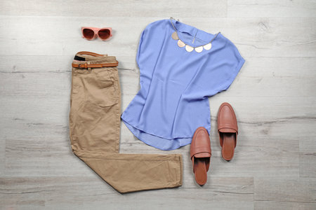 Set of stylish clothes and accessories on wooden floor, flat layの写真素材