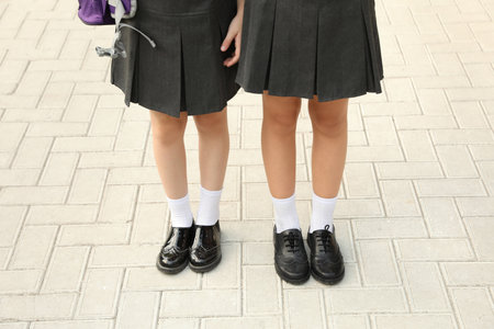 Girls in stylish school uniform outdoors, focus on legsの写真素材