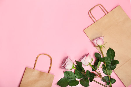 Stylish flat lay composition with shopping bags and flowers on color backgroundの写真素材