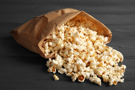 Paper bag with tasty popcorn on wooden backgroundの写真素材