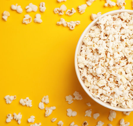 Paper bucket with tasty fresh popcorn on color background, top viewの写真素材