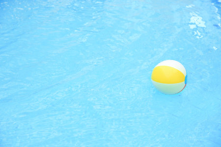 Colorful inflatable ball floating on water in swimming pool