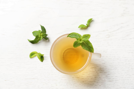 Cup with hot aromatic mint tea and fresh leaves on table, top viewの写真素材