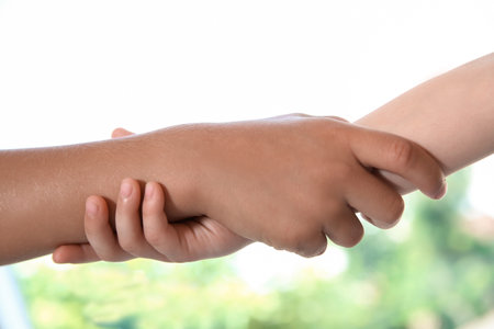 Children holding hands on blurred background, closeup. unity conceptの写真素材