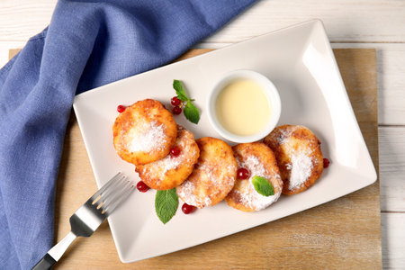 Plate with cottage cheese fritters on table, top viewの写真素材