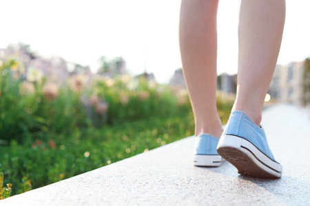 Woman in stylish sneakers walking outdoors, closeup. urban fashionの写真素材