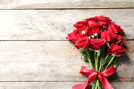 Beautiful red rose flowers on wooden background, top viewの写真素材