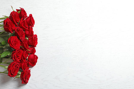 Beautiful red rose flowers on wooden background, top viewの写真素材