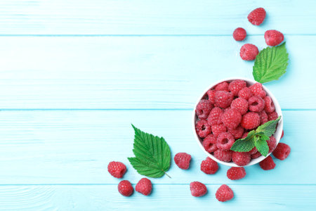Bowl with ripe aromatic raspberries on wooden table, top viewの写真素材