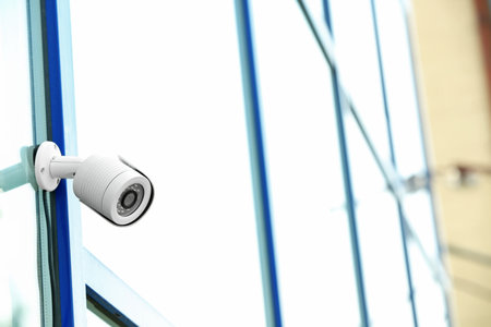 Modern security CCTV camera on wall outdoors