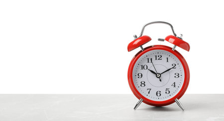 Alarm clock on table against white background. time conceptの写真素材