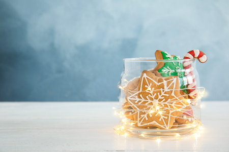 Glass jar with tasty homemade Christmas cookies on table