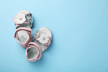 Pair of cute baby sandals on color background, top viewの写真素材