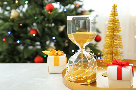 Hourglass with gifts and festive decor on table. christmas count downの写真素材