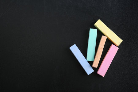 Color pieces of chalk on blackboard, top viewの写真素材