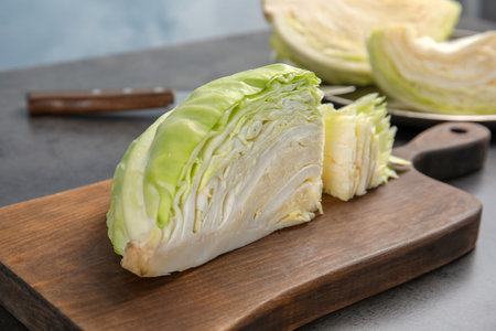 Wooden board with cut cabbage on tableの写真素材