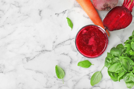 Glass of fresh beet juice and vegetables on table, top viewの写真素材
