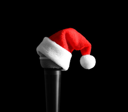 Microphone with Santa hat on black background. christmas music conceptの写真素材
