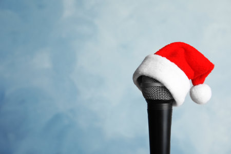 Microphone with Santa hat on color background. christmas music conceptの写真素材