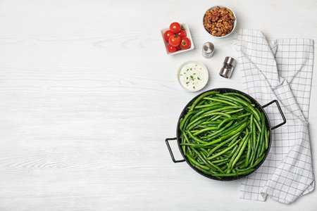 Flat lay composition with tasty green beans on wooden table