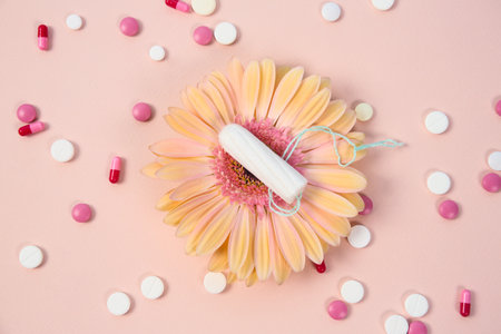Flat lay composition with flower, pills and tampon on color background. Gynecological checkupの写真素材
