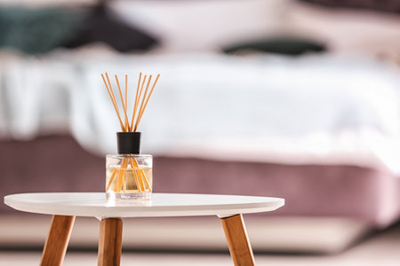 Aromatic reed air freshener on table against blurred backgroundの写真素材