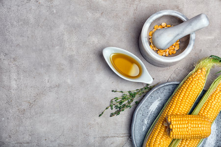 Flat lay composition with gravy boat of corn oil, cobs and kernels on light backgroundの写真素材