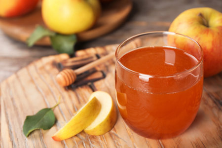 Glass of honey and apples on wooden boardの写真素材