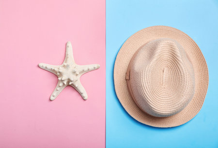 Stylish hat and sea star on color background, top view. beach resortの写真素材
