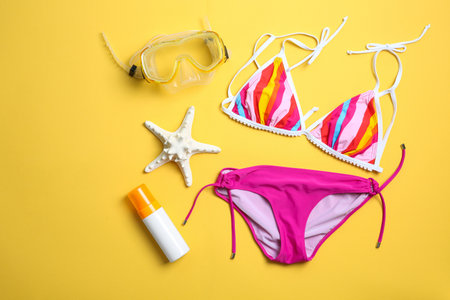 Flat lay composition with bikini and beach objects on color backgroundの写真素材