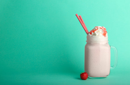 Mason jar with delicious milk shake on color backgroundの写真素材