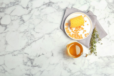 Flat lay composition with corn and jug of oil on marble backgroundの写真素材