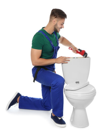 Young man working with toilet tank, isolated on whiteの写真素材