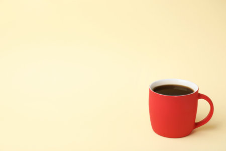 Red ceramic cup with hot aromatic coffee on color backgroundの写真素材