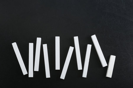 Pieces of chalk on blackboard, top view