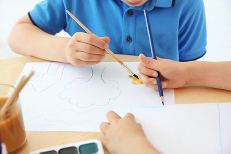 Cute little children painting at table in playing room