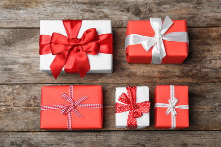 Flat lay composition with beautiful gift boxes on wooden background