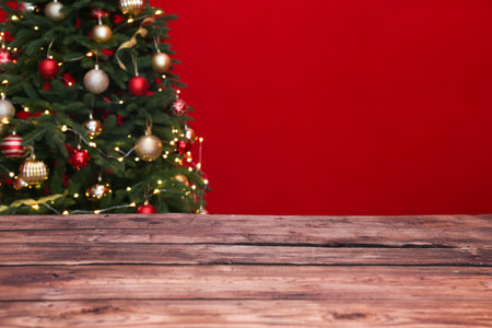 Wooden table and blurred Christmas tree with fairy lights on backgroundの写真素材