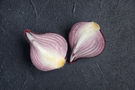 Ripe cut red onion on dark background, top viewの写真素材